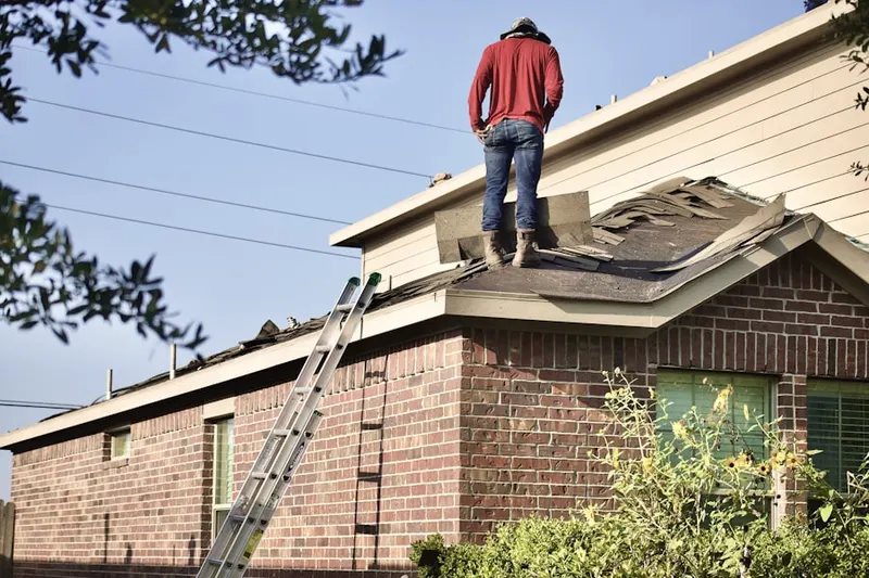 Professional roofer working on a residential roof in Webster Park North